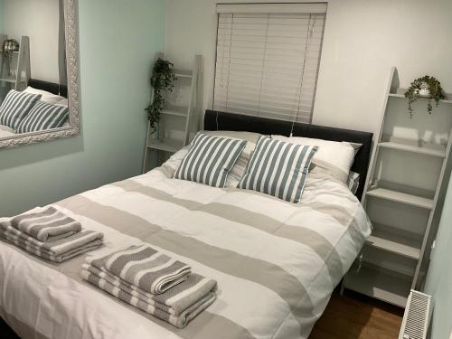 a bedroom with a bed with two towels on it at 1 bed Home from Home Apartments in London