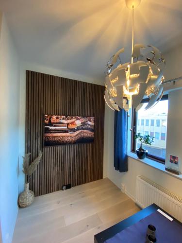 a large chandelier in a room with a bed on a wall at Moderne leilighet midt i sentrum av Fredrikstad in Fredrikstad