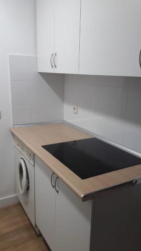 kuchnia z białymi szafkami i czarnym blatem w obiekcie Piso 3 dormitorios junto al metro Nueva Numancia, a 15 min de Sol en metro w Madrycie