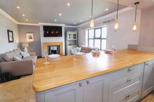 a kitchen with a large island in a living room at Honeybee Cottage in Lincolnshire