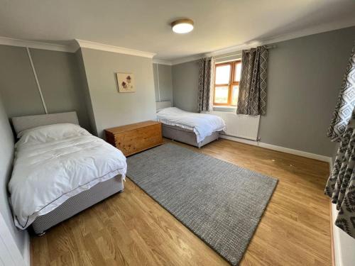 a bedroom with two beds and a rug at Hear Lions Roar while enjoying a beautiful holiday in Lincolnshire