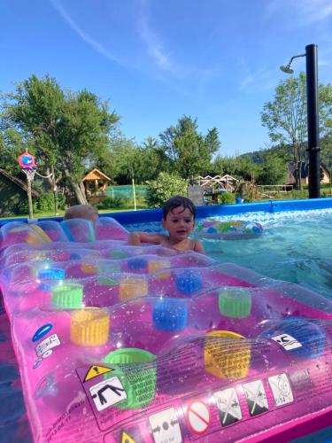 a young boy swimming in a inflatable pool at a water park at Agroturystyka Pod Modrzewiem in Zubrzyca Górna