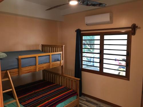 a bedroom with two bunk beds and a window at Moonrise Beach in Placencia