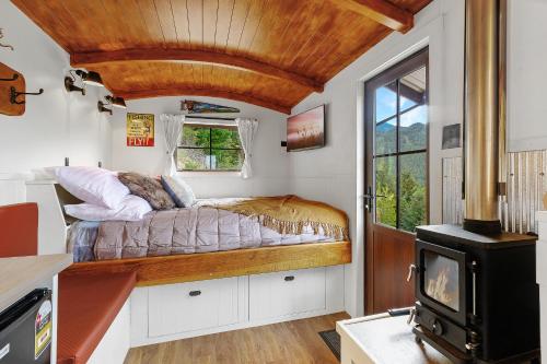 a bedroom with a bed in a room with a fireplace at The Shepherds Hut - boutique retreat. in Hanmer Springs