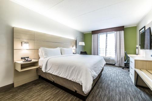 a hotel room with a large bed and a window at Holiday Inn Express Flint-Campus Area by IHG in Flint