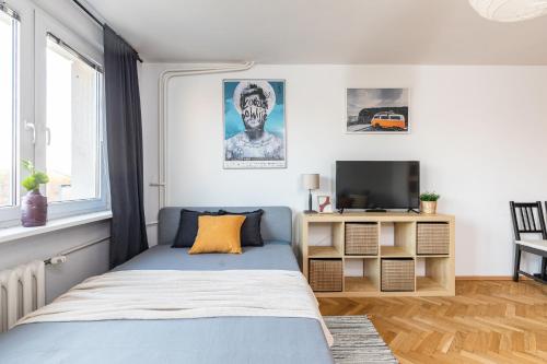 a bedroom with a blue bed and a television at SuperApart ulica Wilanowska 10 in Warsaw