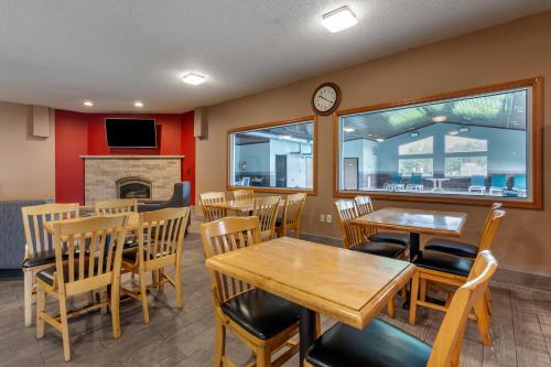 a restaurant with tables and chairs and a fireplace at Quality Inn Redgranite in Redgranite