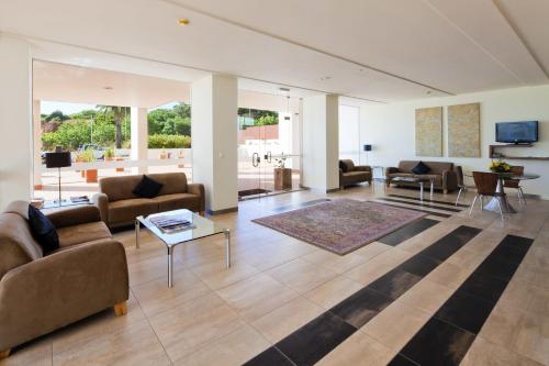 una gran sala de estar con sofás y una mesa. en Villa Doris Suites, en Lagos
