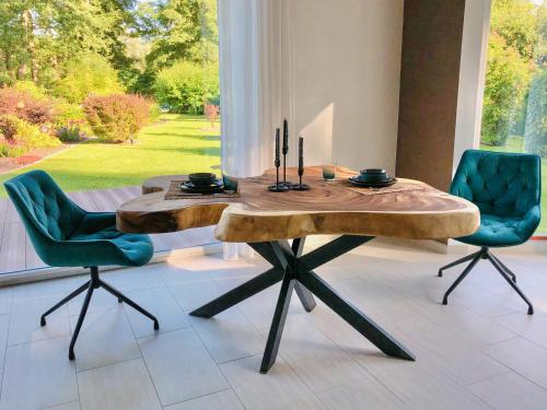 uma sala de jantar com uma mesa de madeira e 2 cadeiras em Ferienhaus direkt an der Spree mit Whirlpool und Sauna em Berlim