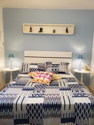 a bedroom with a blue and white bed with two tables at Geriba Apart Hotel in Búzios