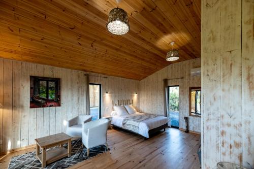 um quarto com uma cama e um tecto de madeira em le lodge en mormal em Louvignies-Quesnoy