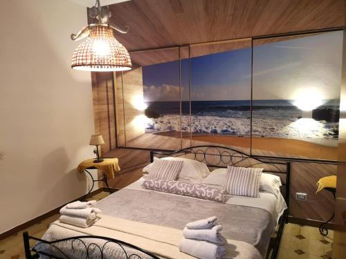 the lighthouse accommodation في تارانتو: غرفة نوم بسرير مع صورة للمحيط