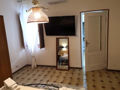 a room with a lamp and a mirror and a television at the lighthouse accommodation in Taranto