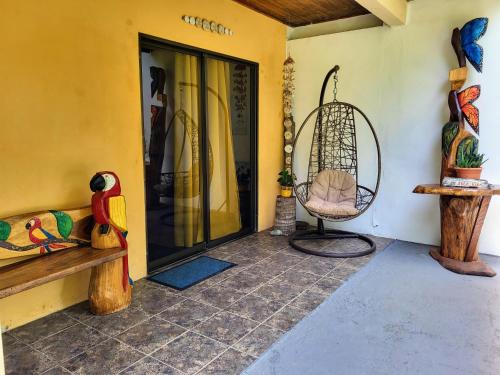 a porch with a swing and a chair next to a door at Villas Playa Palo Seco in Parrita