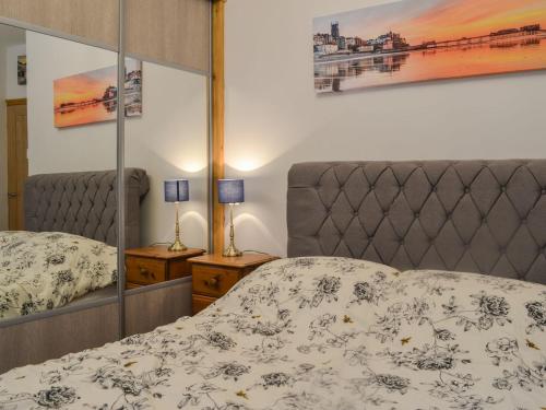 a bedroom with a bed and a mirror at Primrose Cottage - Uk41346 in Cromer