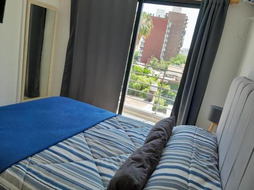 1 dormitorio con cama y ventana en París 1 Monoambiente en Rosario