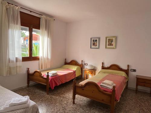 1 dormitorio con 2 camas y ventana en Casa la Pineda Salou, playa y Port Aventura en Salou