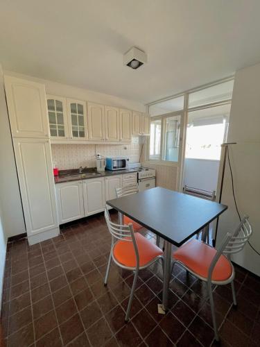 cocina con mesa, 2 sillas y refrigerador en APART CIUDAD MENDOZA en Mendoza
