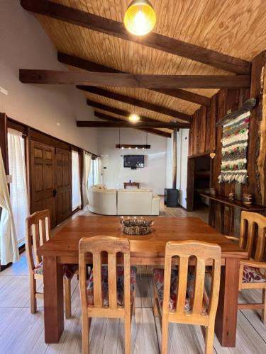 a dining room with a wooden table and chairs at Cabañas Alto Bosque in Pucón