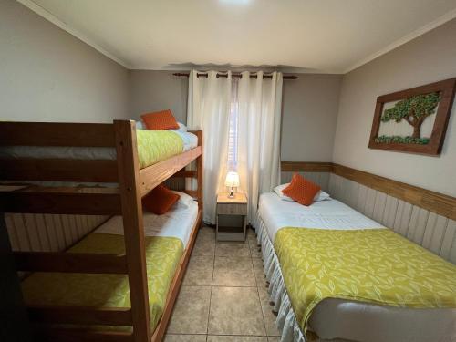 a bedroom with two bunk beds and a window at Cabañas Alto Bosque in Pucón