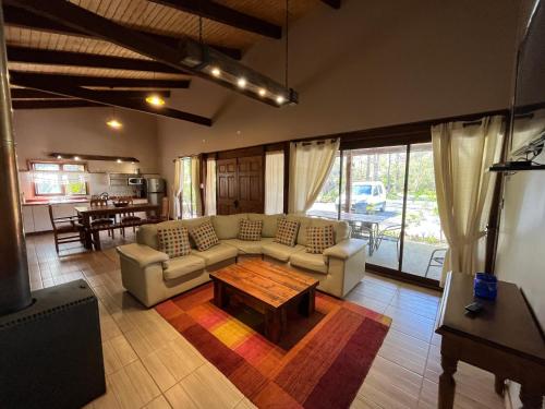 a living room with a couch and a table at Cabañas Alto Bosque in Pucón