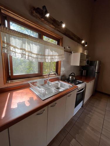 a kitchen with a sink and a window at Cabañas Alto Bosque in Pucón
