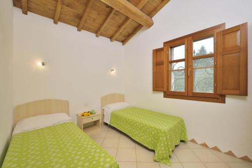 a bedroom with two beds and a window at Residence Le Zagare in San Teodoro