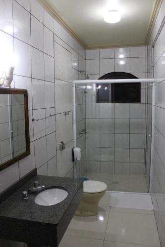 a bathroom with a toilet and a sink and a mirror at Hotel Colina Verde in Concordia