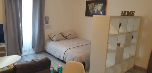 um pequeno quarto com uma cama e uma estante de livros em Appartements entiers proche Aéroport - ZAC Chesnes - CNPE du Bugey Check-In 24h7J em Satolas-et-Bonce
