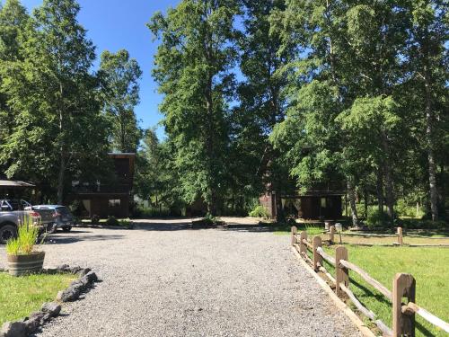 a gravel driveway with a fence and a building at Cabañas Alto Bosque in Pucón