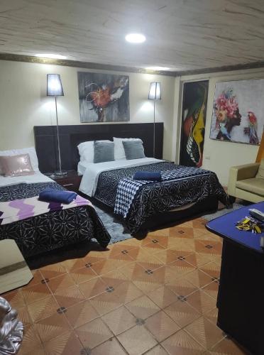 Dos camas en una habitación de hotel con dos en CASA MUY CONFORTABLE EN ZAMORA CHINCHIPE incluye desayuno, en Zamora