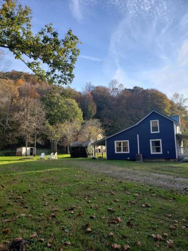 a blue house in the middle of a yard at Red River Gorge Farmhouse 50 Acres in Stanton