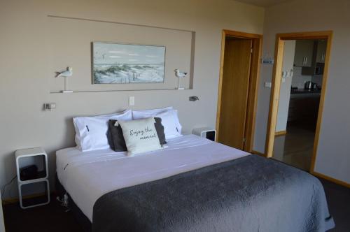 a bedroom with a large bed with a pillow on it at Rocky Cape Retreat in Rocky Cape