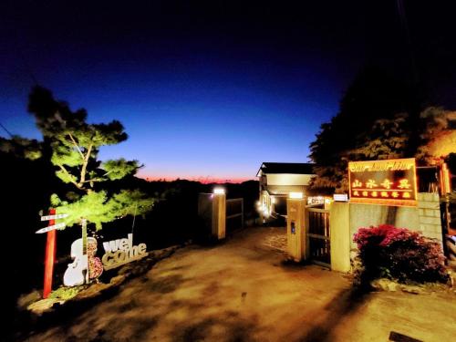 a night view of a house with a sign in front at 山水奇異San Shuei Kiwi桃園市民宿編號038 Homestay in Sanmin