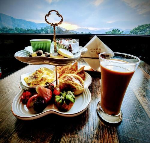a table with two plates of food and a drink at 山水奇異San Shuei Kiwi桃園市民宿編號038 Homestay in Sanmin