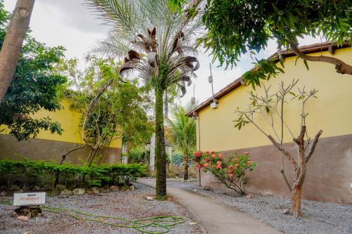 a garden with a hose in front of a yellow building at Pousada Kabana de Pedra in Ibicoara