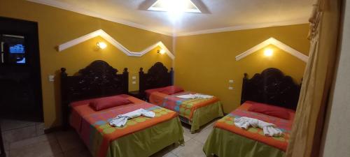 Llit o llits en una habitació de Hotel Tinamit