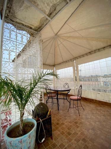 a room with a table and chairs and a plant at Riad Najiba in Rabat