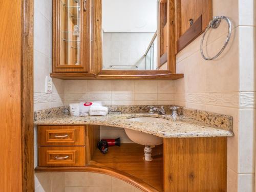 a bathroom with a sink and a mirror at Palladio 304 - Gramado 400 metros Rua Coberta in Gramado