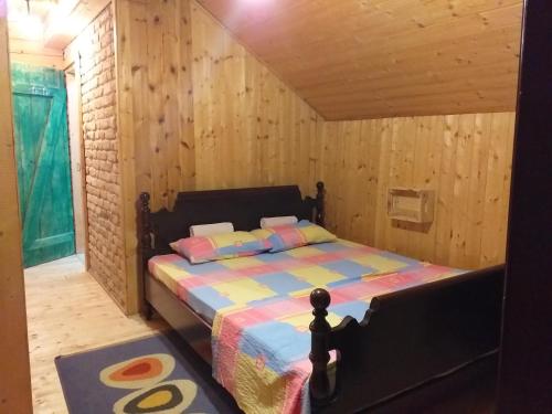 um quarto com uma cama num quarto de madeira em Lodging Vidmar em Sremski Karlovci