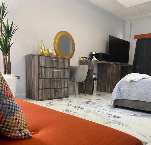 Schlafzimmer mit einem Bett, einem Schreibtisch und einem Spiegel in der Unterkunft Itza-Bella Suites in Isabela