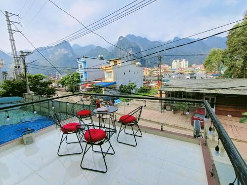 uma varanda com cadeiras e uma mesa com vista em Nhà Nghỉ QUANG TRUNG em Dong Van