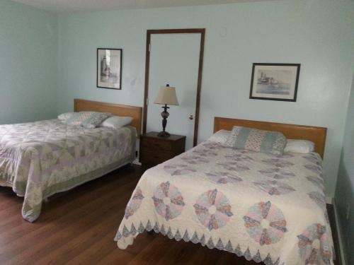 a bedroom with two beds and a mirror at Chaffee Lodge in Chaffee