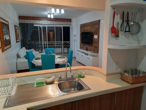 a kitchen with a sink and a living room at Carabelas de Colon con balcon grande y vista hermosa in Playas