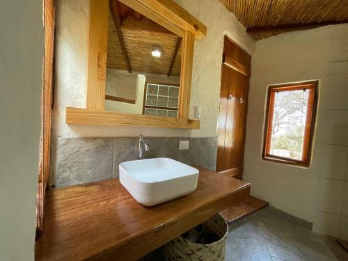 a bathroom with a white sink on a wooden counter at Vista del Mar Casa y Bungalows in Máncora