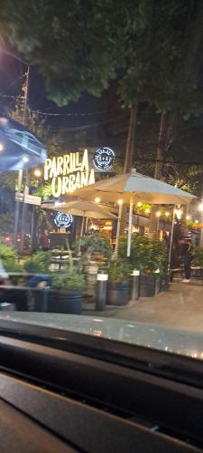 Habitaciones Narvarte Del Valle في مدينة ميكسيكو: مطعم أمامه مظله ونباتات