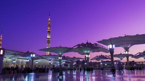 a city with a mosque in the background at night at Crowne Plaza Madinah by IHG in Al Madinah