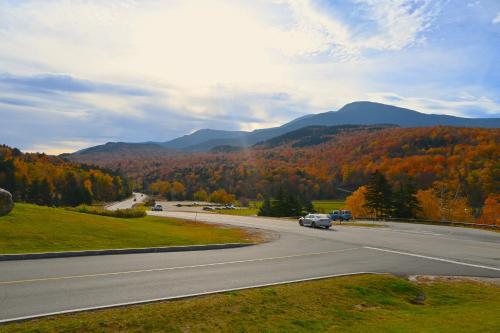 a car driving down a road with mountains in the background at The Lodge at Jackson Village in Jackson