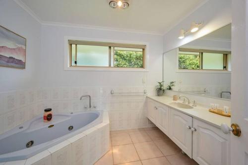 a white bathroom with two sinks and a tub at A kids dream & paradise for parents in Ocean Shores