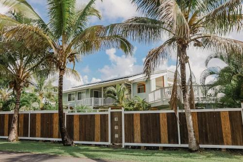 a house with palm trees in front of it at Pahoa Paradise Palms in Pahoa